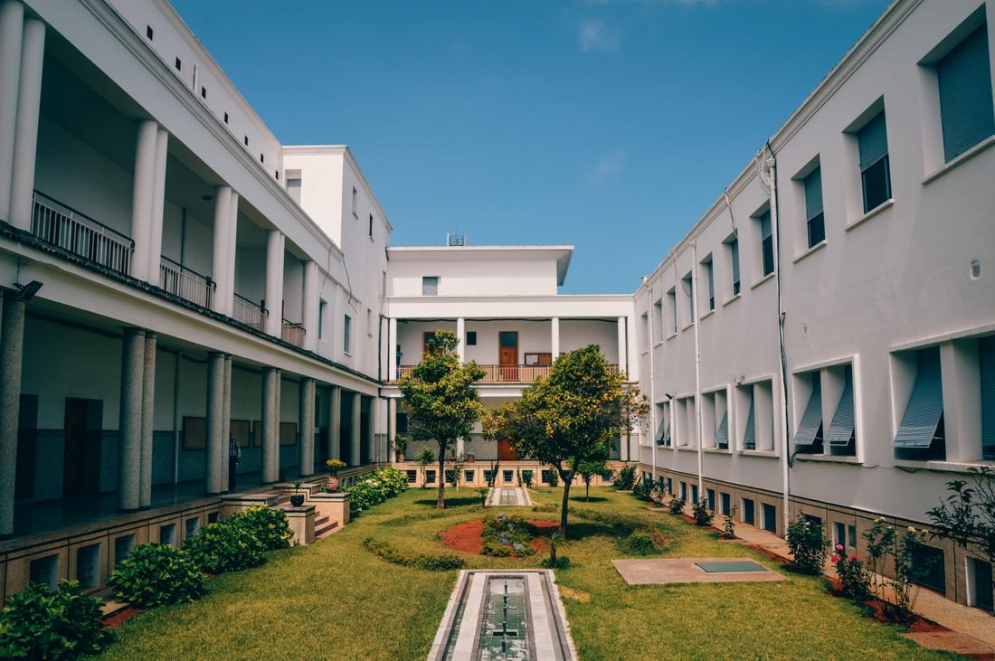 Illustrative modern school facade with a landscaped courtyard